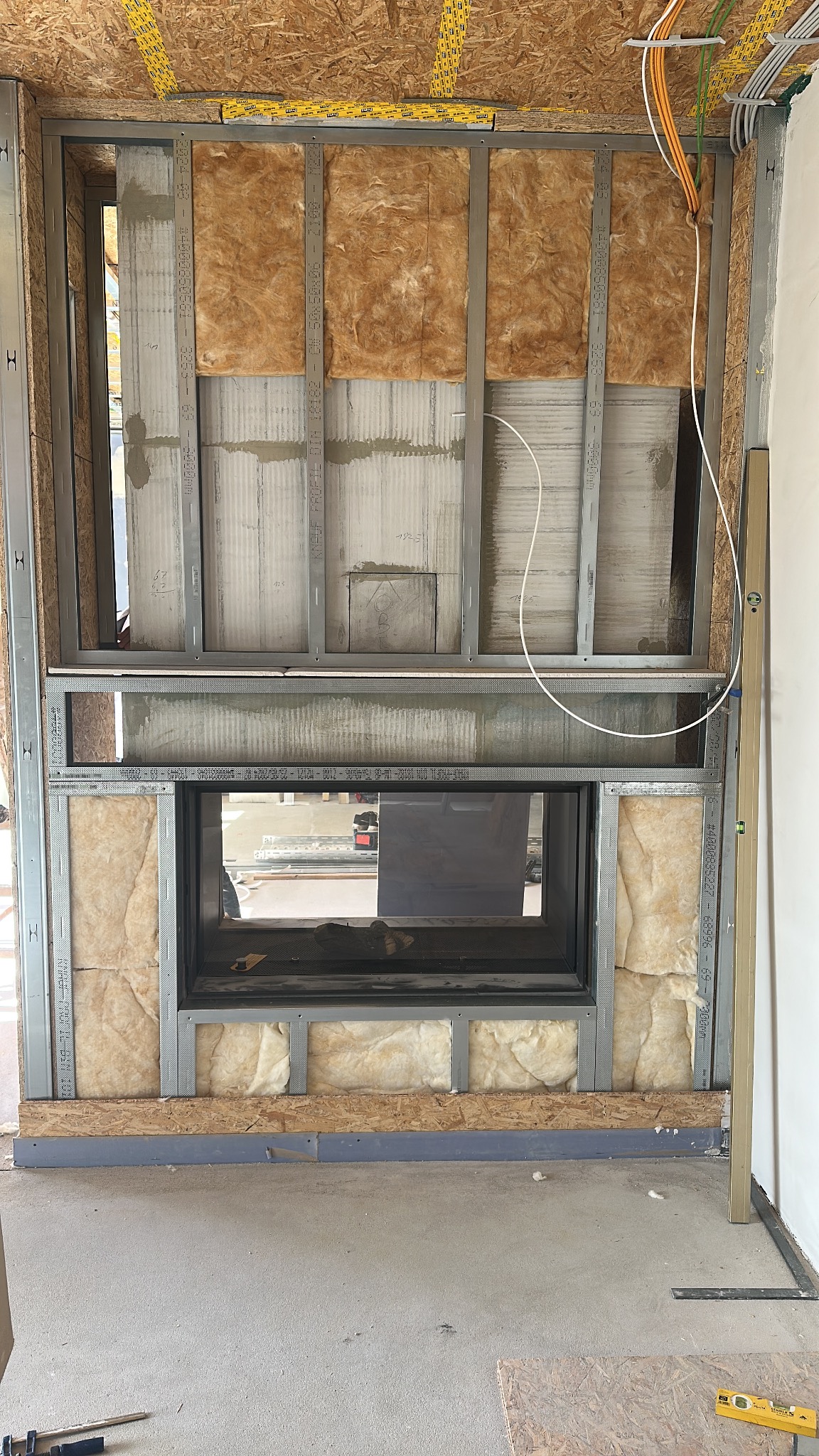 Metallständerwerk mit Dämmung und integriertem Kamin während der Renovierung