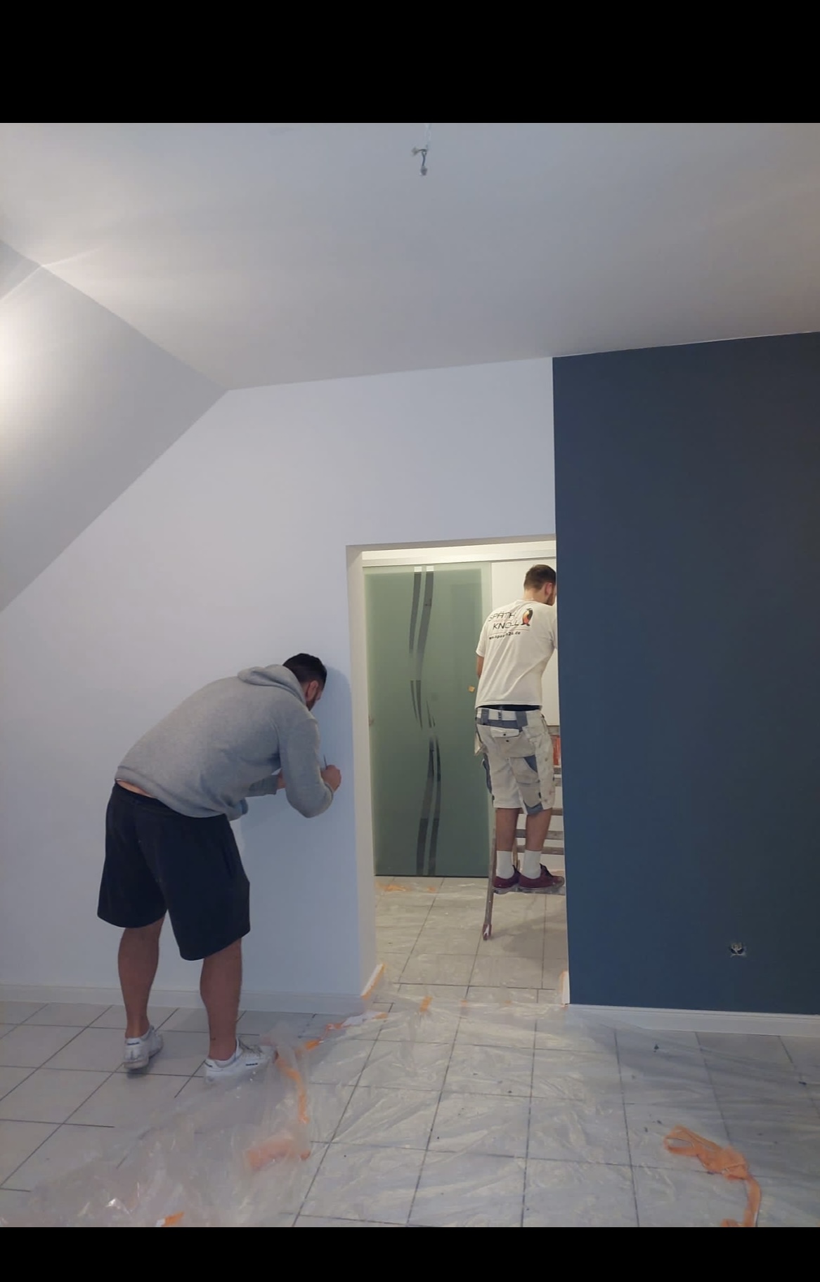 Maler bei der Arbeit an einer zweifarbigen Wand