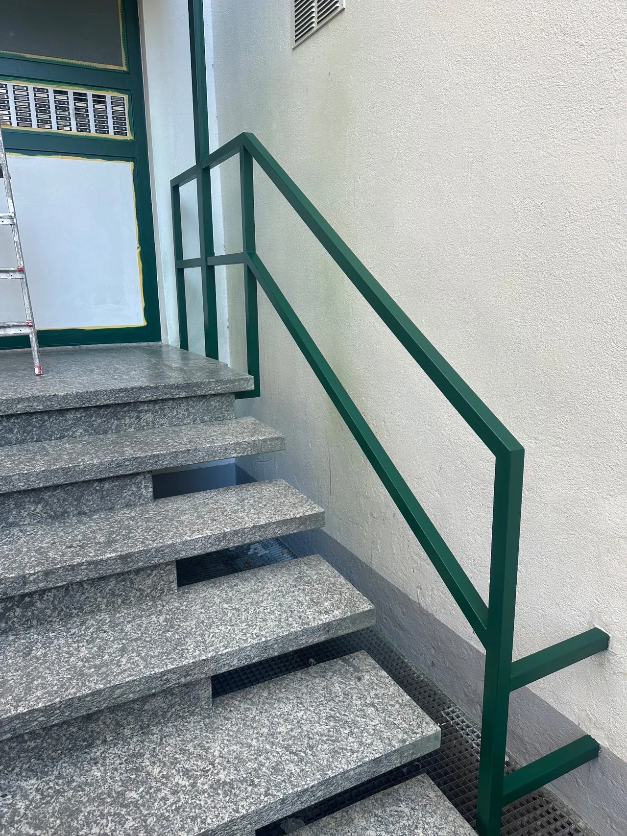 Frisch lackiertes Geländer auf Granitstufen